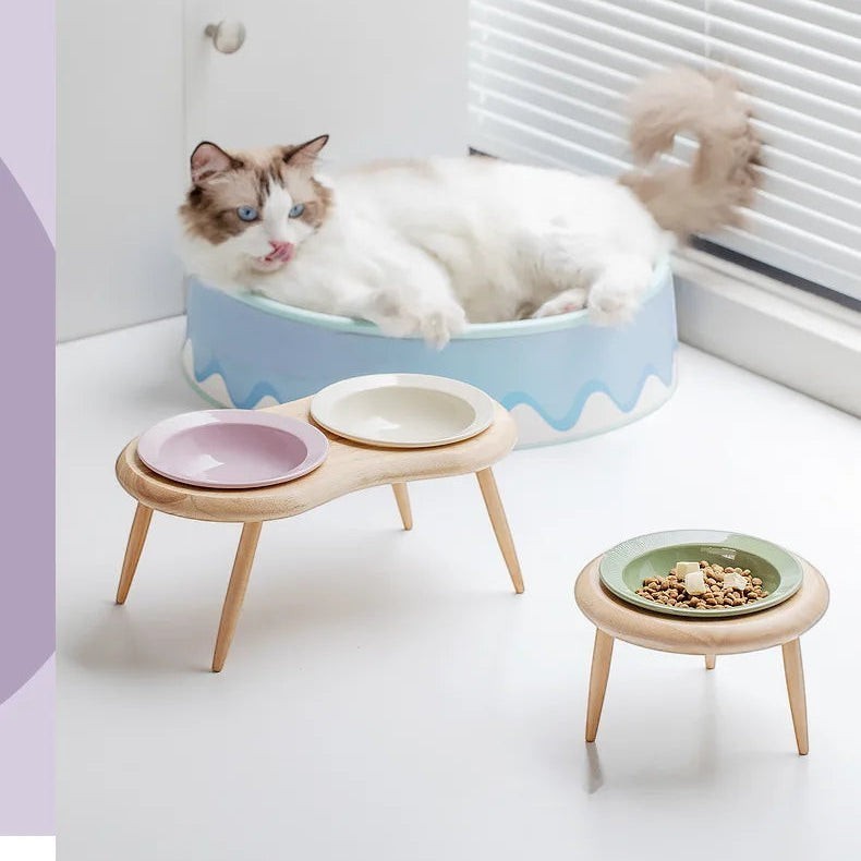 Double gamelle surélevée Bofélin en bois avec bols en céramique pastel pour chat, favorisant une posture confortable.