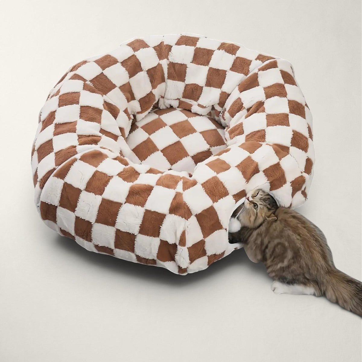 Lit tunnel Bofélin 2 en 1 en velours doux taupe et blanc à motif damier avec un chat jouant à l'entrée