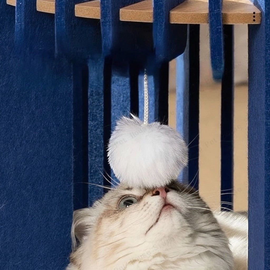 Niche pour chat Bofélin cylindrique en feutre bleu nuit et bois avec pompon blanc suspendu pour jouer