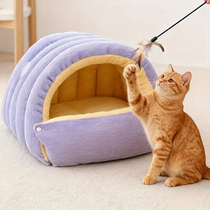 Niche chausson Bofélin lilas en velours côtelé avec intérieur en fausse fourrure beige pour chat jouant avec une plume