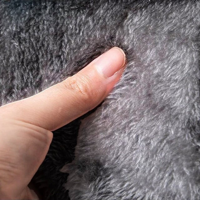Gros plan sur la texture douce en fausse fourrure grise du panier niche pour chat Bofélin