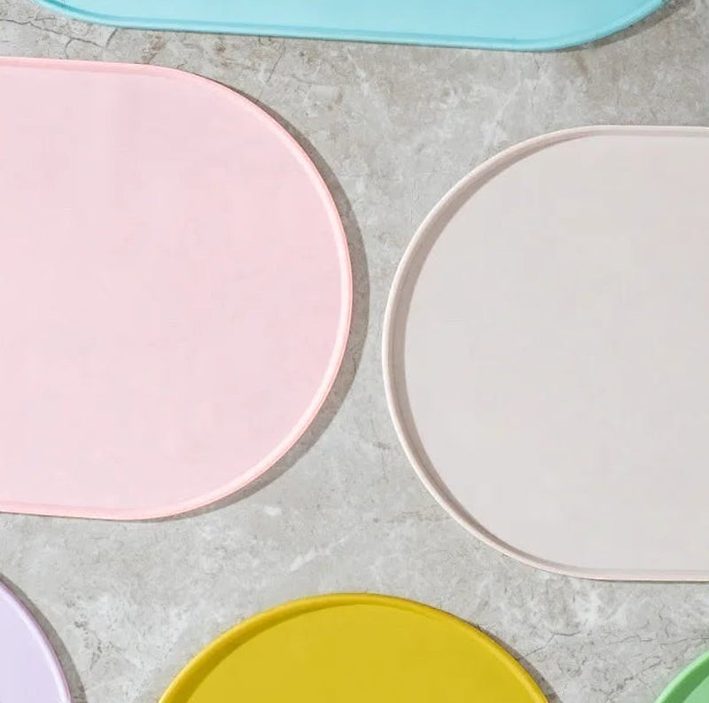 Tapis de gamelle Bofélin en silicone ovale, antidérapant et imperméable, disponible en plusieurs coloris pastel.