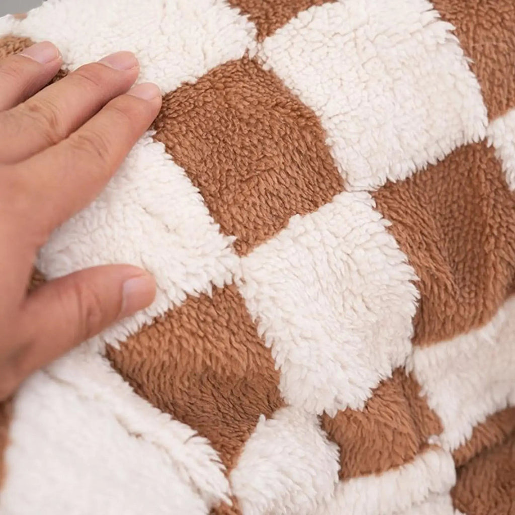 Gros plan sur la texture en velours doux à carreaux marron et blanc du lit tunnel pour chat Bofélin