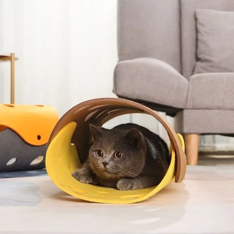 Chat gris couché dans un tunnel de jeu modulable en feutre jaune et marron de la marque Bofélin avec des trous